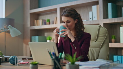 Calm employee drinking coffee in morning office. Smiling business manager rest