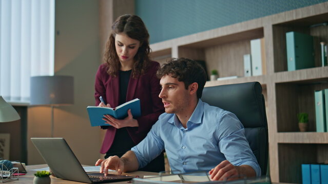 Secretary writing boss instructions standing company office. Ceo giving tasks