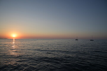 imbarcazione a vela naviga in mezzo al mare al tramonto