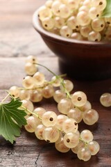 Fresh white currant berries and green leaf on wooden table, closeup