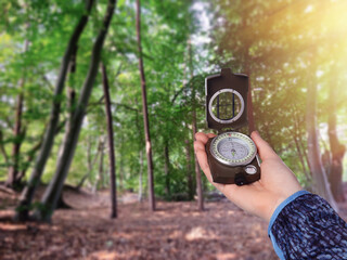 Naklejka premium Woman holding compass in beautiful forest, closeup