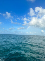 Beautiful peaceful open blue tropical ocean water with blue skies and clouds on a summer day