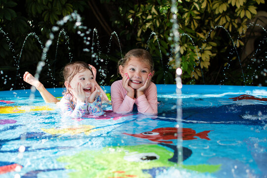 Happy children in a pool. Happy childhood concept. Laughing kids enjoying summer at the splash pad