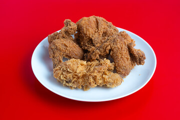 Crispy Fried chicken on a white plate isolated on red background. Perfect for recipes, articles or any cooking content.