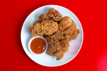 Crispy Fried chicken on a white plate isolated on red background. Perfect for recipes, articles or any cooking content.