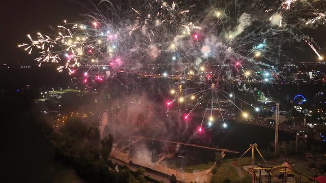 Drone flight through the Holiday fireworks above water with reflection near Jacques Cartier Bridge, Jean-Drapeau Park. Montreal, Quebec, Canada.