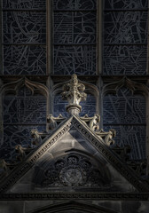 Sun shines through the surface of Stained Glass Arched Windowand The Gable is above the entrance door of St.Giles's Cathedral in Edinburgh. Exterior architectural detail of the High Kirk in Neo-gothic