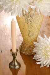 Closeup still life of a pink candle a yellow vintage vase and a white flower