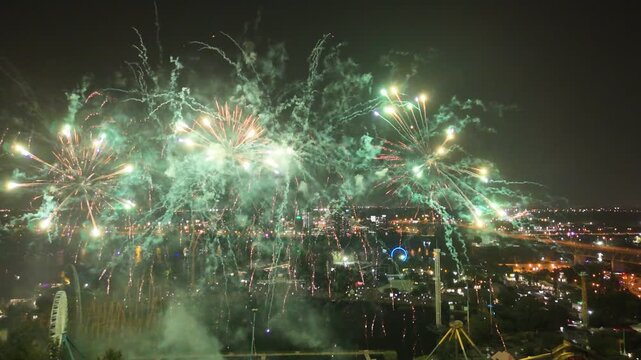 Drone flight through the Holiday fireworks above water with reflection near Jacques Cartier Bridge, Jean-Drapeau Park. Montreal, Quebec, Canada.