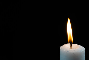 lit candle on corner isolated black background