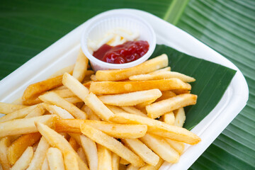 Delicious french fries on eco-friendly plate with ketchup for dipping.
