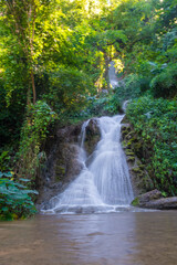 Obraz premium Amazing waterfall in tropical forest sun light on green tree nature landscape