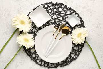 Table setting with beautiful gerbera flowers on beige grunge background