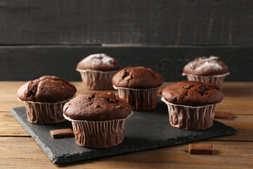 Tasty chocolate cupcakes on wooden table