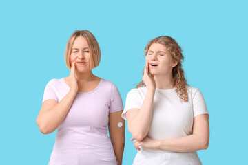 Beautiful women suffering from toothache on blue background