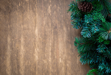 Merry Christmas and Happy New Year concept. Close-up green Christmas tree decorated with pinecone on old wooden board background with copy space, festive party ornament banner, simple style.