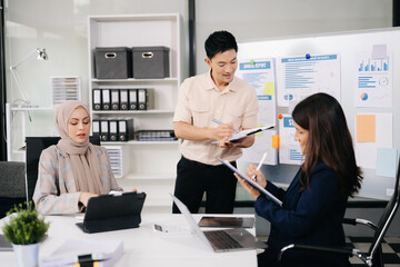 Group of young business people discussing business plan at modern startup in creative business discussing work modern office building.