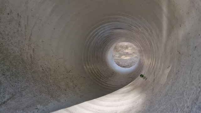 the sound of a spinning ball spiraling through a plastic tube on a children's playground. children have fun with the rolling speed and the length of the circular motion