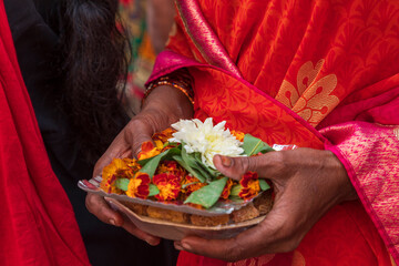 India, Uttar Pradesh, Varanasi, Harha. Close-up of a woman's hands holding a dish of flowers.