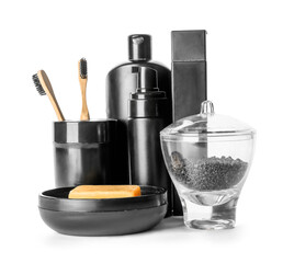 Set of bath accessories and jar with black sea salt on white background