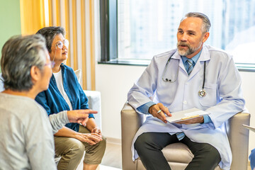 Group of senior people listening to male doctor. The doctor is describing the patient's condition with a data file in the hospital, Elder care, medicare services for older concept