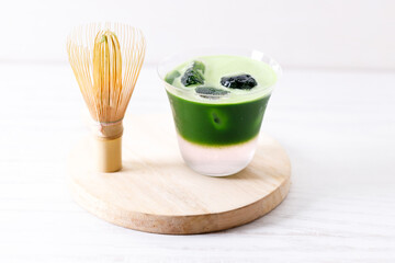 Refreshing matcha drink with pink coconut water presented in multiple layers with rock ice.