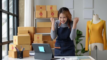 Start up small business entrepreneur SME or freelance asian woman using laptop with box, Young success Asian woman with her hand lift up , online marketing packaging box and delivery, SME concept.