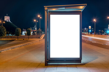 Blank Mockup Of Bus Stop Vertical Billboard On The Sidewalk At Night. Front View Of White Empty Outdoor Advertising Screen