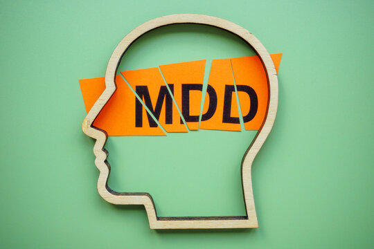 The outline of the head and a cut piece of paper. MDD Major Depressive Disorder.