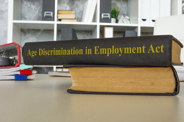 Office desk with book Age Discrimination in Employment Act ADEA.