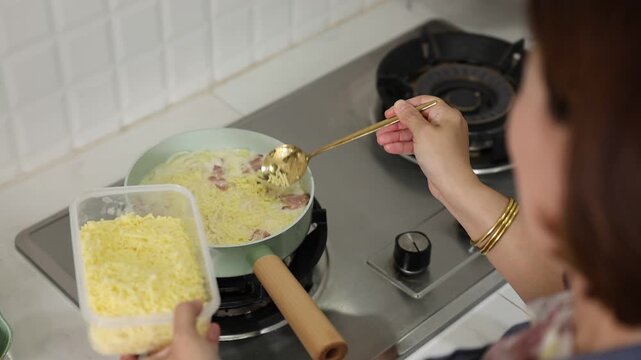 Chef is cooking spaghetti carbonara in the kitchen