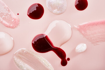 Lip gloss transparent drops and samples on pastel pink background