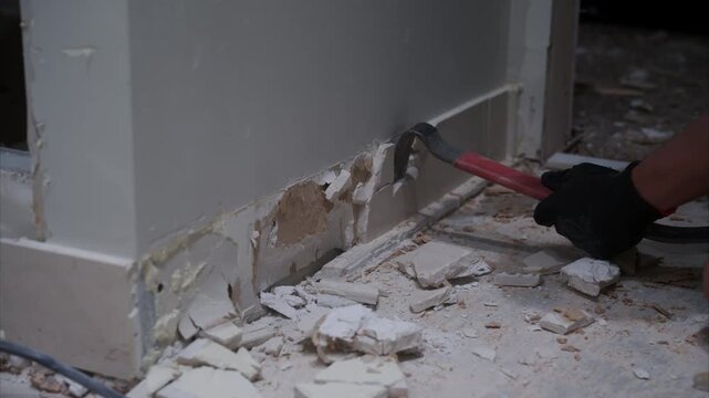 Demolition of a wall in room. Removing tiles from the wall. Dismantling and renovation of apartment in house