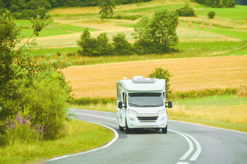 RV traveling scenic route by green countryside