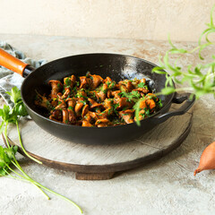 frying pan with fried chanterelles on the table