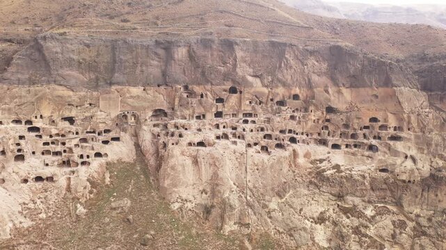 Complex of cave monastery structures carved into mountain in historic city of Vardzia, important archaeological site and tourist attraction in Georgia
