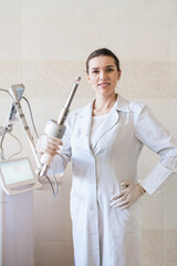 female doctor holds in her hands a carbon dioxide laser with a phallic attachment for vaginal...