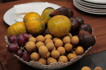 some fruits such as oranges, snake fruit and longan fruit in a plastic basket as a dessert