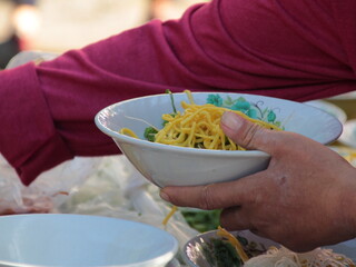a bowl of soto, a typical Indonesian food with shredded chicken and vegetable toppings