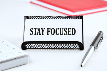 STAY FOCUSED on a business card on a white background