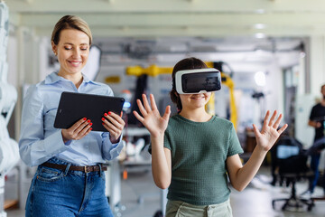 Schoolgirl learning with VR headset on head. Teacher using modern technology, virtual reality during class, lesson.