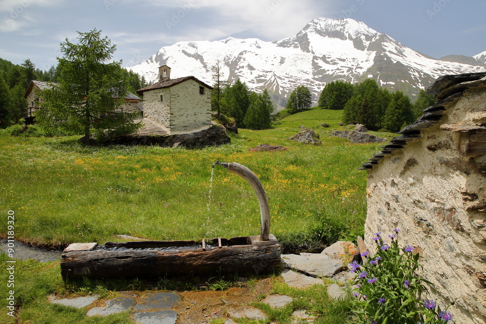 Wall mural The well preserved and listed hamlet Le Monal and its traditional houses, Sainte Foy Tarentaise, Northern French Alps, Savoie, France, with the  summit Mont Pourri in the background