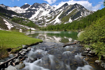 Fototapeta premium Reflections on The Lago Arpy (Arpy lake) located in the Italian Alps, La Thuile, Aosta Valley, surrounded by mountains and glaciers