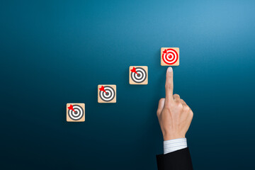 Ladder of success in business growth concept with target icon on wooden cubes