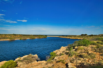 The gorge of the Yardie Creek in Cape Range National Park, Western Australia, with red limestone rocks and stunted outback vegetation
