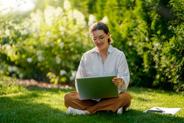 woman working on laptop in summer morning