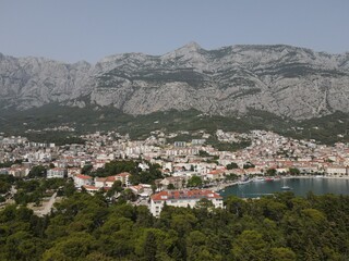 Obraz premium Makarska, Croatia. Coastal town, sea and mountains, Biokovo park. Aerial photography from a drone. Croatian town on the Adriatic Sea. Makarska Riviera
