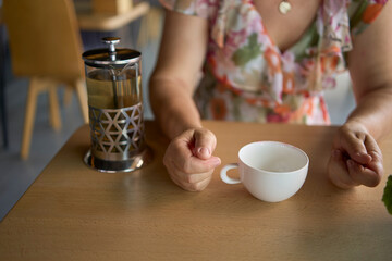 60s woman drinking nettle tea in modern coworking office during lunch break