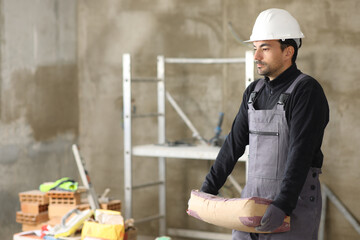Construction worker lifting a concrete bag