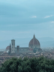 Fototapeta premium A large church with a dome sits on a hill. The sky is cloudy and the sun is not visible
